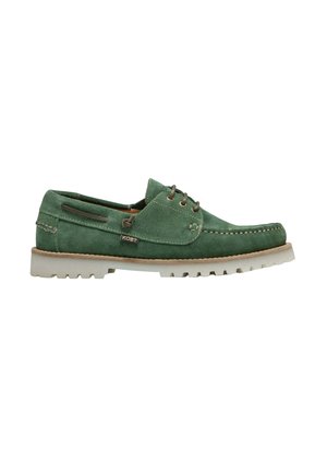 Chaussure bateau en daim vert à lacets avec semelle blanche épaisse à rainures et détail cousu à l'avant, étiquette de marque latérale "KOST" visible.