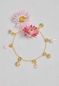 Goldkettenarmband mit Anhängern: pinkes Herz, Perlenmuschel, Schildkröte, Seestern und Blumen. Glatte Oberfläche mit verschiedenen Formen und Farben.
