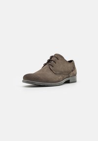 Scarpa da uomo marrone per cerimonia con una sottile trama a zigzag, modello con lacci e tacco basso su uno sfondo bianco uniforme.