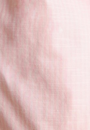 Helle rosa Stoff mit einem subtilen Karomuster, das dünne weiße Linien aufweist. Die Textur wirkt glatt und leicht zerknittert.