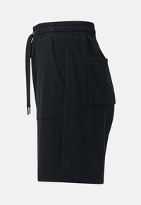 Shorts noirs décontractés avec ceinture élastique, cordon latéral et grande poche latérale, vus de profil gauche sur fond uni.