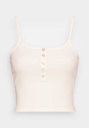 Jasne beżowe prążkowane topy w fasonie crop z cienkimi ramiączkami oraz zapięciem na guziki z przodu, wyposażone w sześć okrągłych, gładkich guzików. Teksturowany materiał o dopasowanym kształcie.
