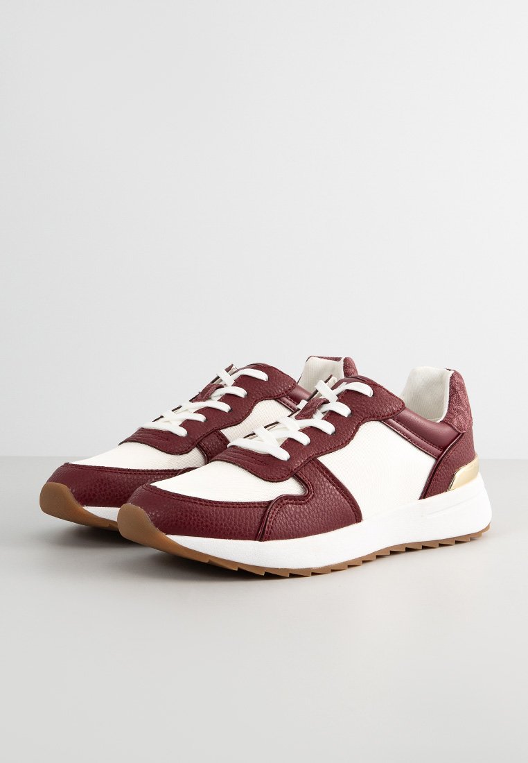 Zapatillas en color burdeos y blanco con parte superior de cuero y textil, diseño con cordones, detalles texturizados y una suela de goma ligera. Detalles en dorado.