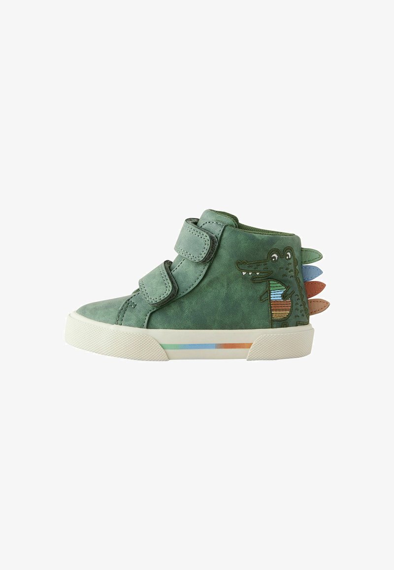 Chaussure haute en cuir vert avec des straps Velcro, présentant un design crocodile et des picots colorés sur le talon, ainsi qu'une ligne d'accent multicolore sur la semelle.