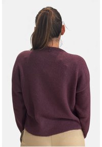 Maglione viola con vestibilità comoda, tessitura a maglia, scollatura rotonda e spalle scese. La parte posteriore presenta un piccolo dettaglio a cucitura.