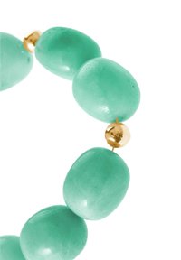 Collier en perles turquoise composé de pierres lisses et arrondies, entrecoupées de perles globales dorées brillantes.