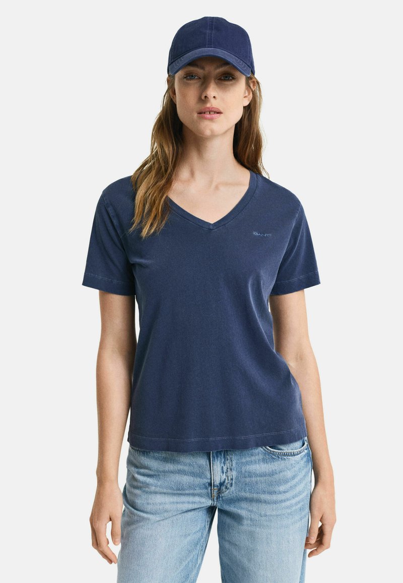 Marineblå v-hals t-shirt lavet af letvægtsbomuld, med korte ærmer og en afslappet pasform, parret med en matchende baseballcap.