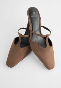 Ruske nubuk slingback čizme s šiljastim nožnim prstima, s jednim remenom preko stopala i jastučićem uložkom označenim "FOREVER COMFORT".
