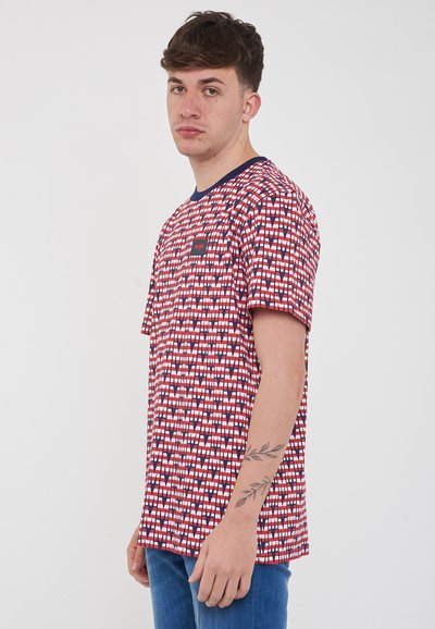 T-shirt a maniche corte rosso e blu con un motivo, collo a giro e una piccola etichetta con logo sul petto. Il tessuto sembra leggero.