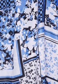 Blauw-wit stoffen patroon met bloemmotieven, geometrische ontwerpen en zwarte accenten. Zachte textuur met een vloeiende val.