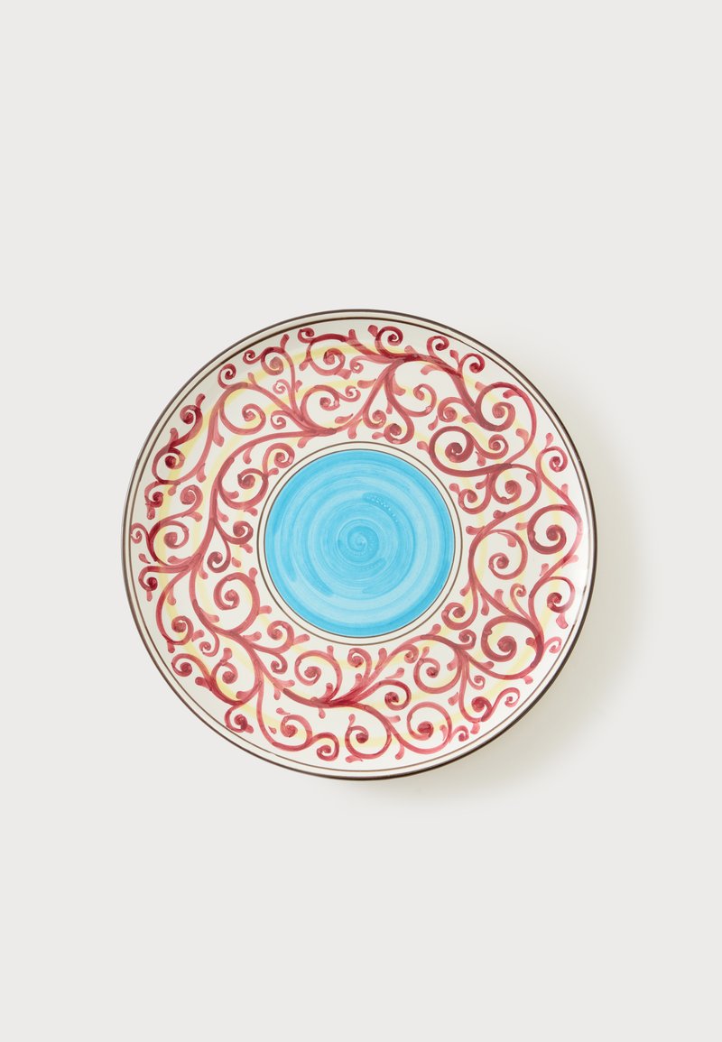 Στρογγυλό κεραμικό πιάτο με μπλε κέντρο και κόκκινα στροβιλιζόμενα μοτίβα κλημάτων σε λευκό φόντο.