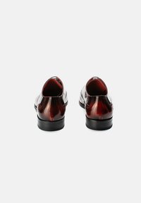 Leder Schuhe mit einem tiefrot polierten Finish, runder Zehenform, niedrigem Absatz, dekorativen Nähten und einer glatten Textur im Obermaterial.