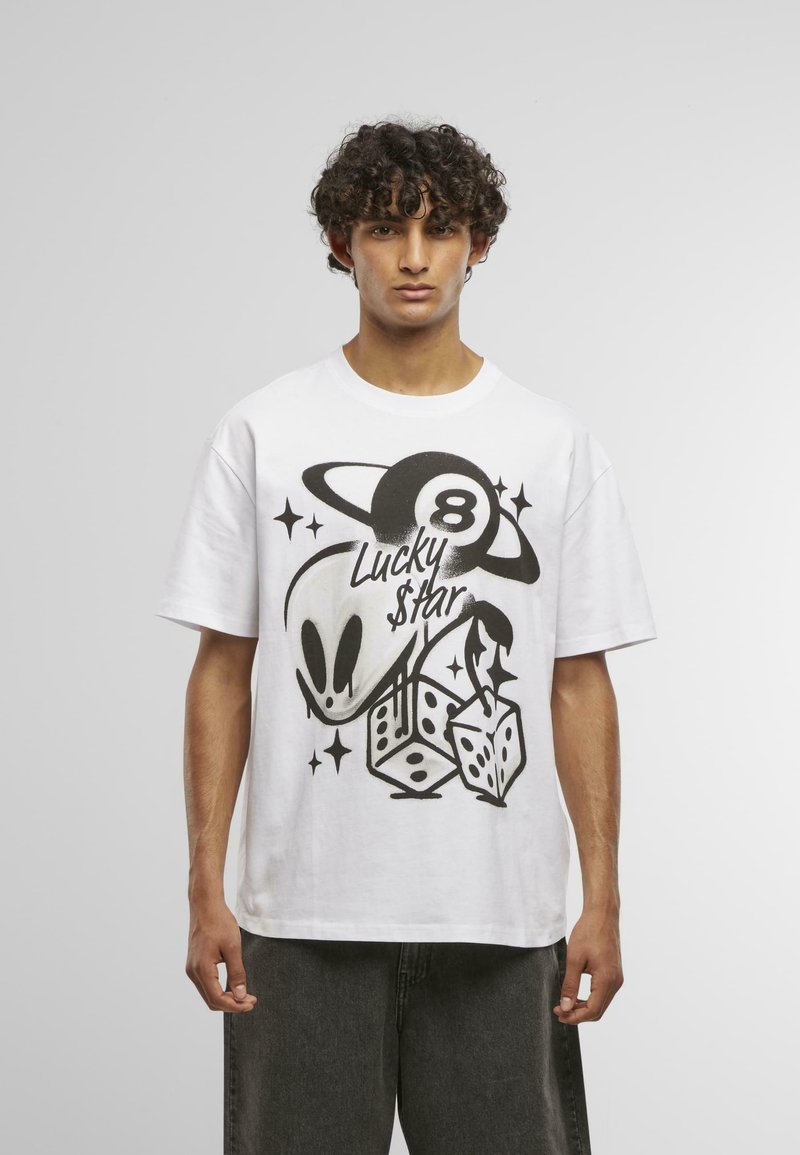 Hvid bomulds T-shirt med et sort grafisk design, der viser en alien, terninger og stjerner, og fremhæver teksten "Lucky $tar" samt tallet 8.