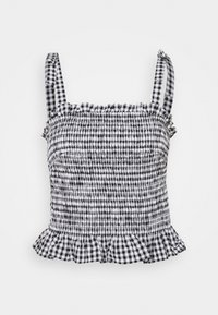 Haut court en vichy noir et blanc, avec tissu smocké, bretelles fines, encolure à volants et ourlet évasé avec un motif à carreaux.