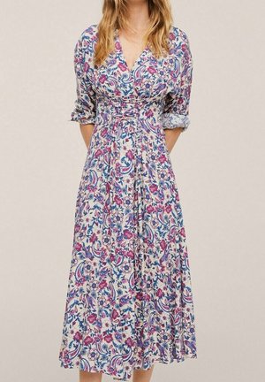Geblümtes Kleid mit weißem Grund und pinken, blauen sowie violetten Mustern. Wickeldesign, V-Ausschnitt und dreiviertellange Ärmel. Knielang.