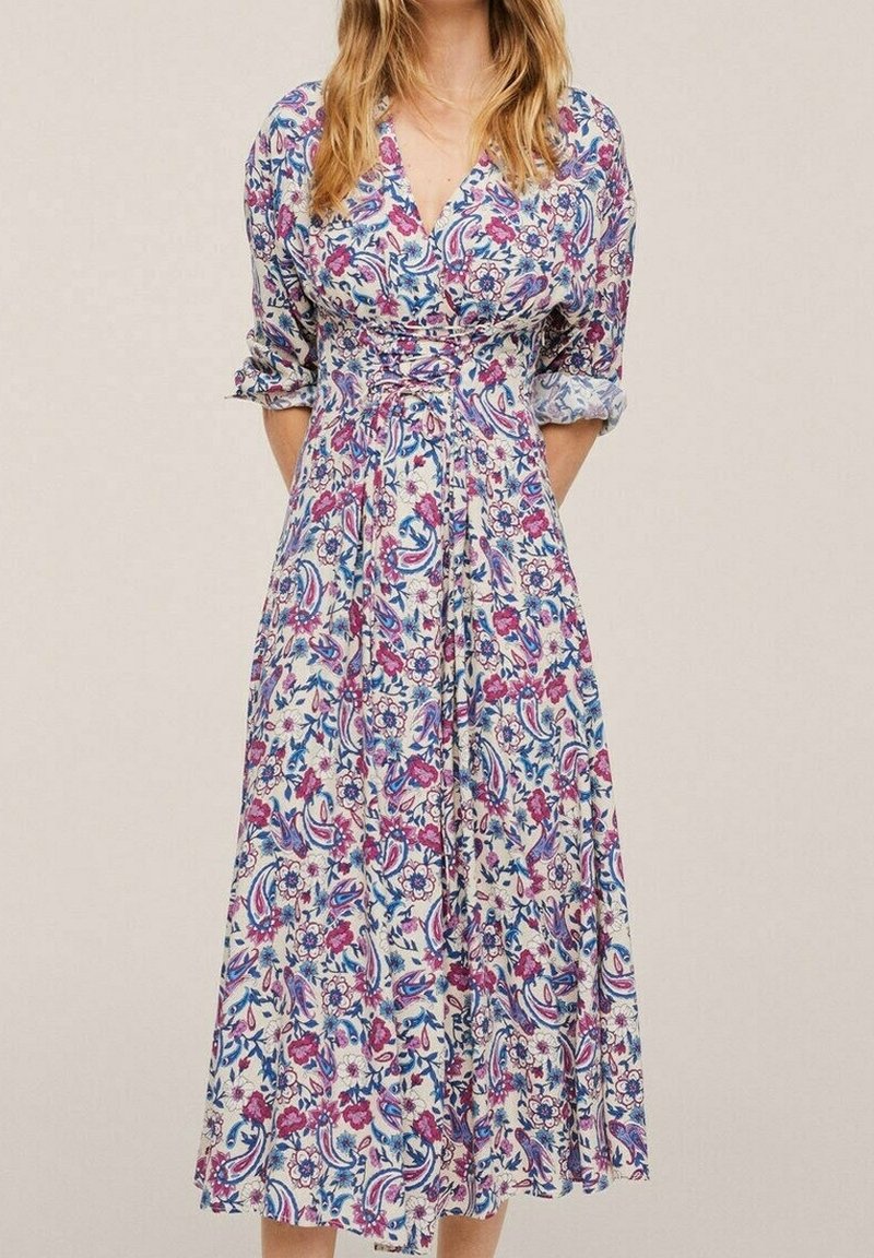 Robe fleurie avec une base blanche ornée de motifs roses, bleus et violets. Design portefeuille, col en V et manches trois-quarts. Longueur au genou.