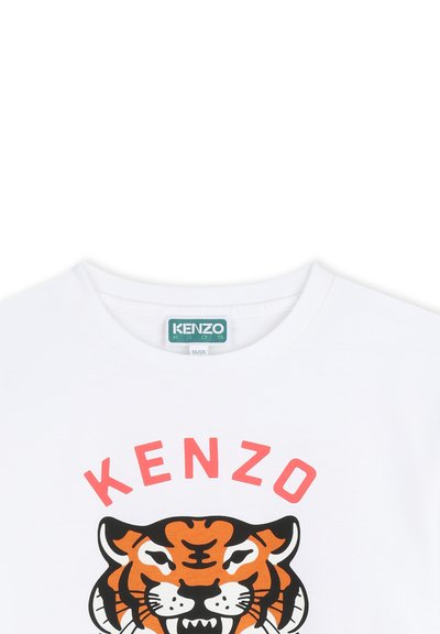 Biała bawełniana koszulka z nadrukiem czarno-pomarańczowego tygrysa oraz napisem "KENZO" w pogrubionym różowym kolorze nad wzorem. Okrągły dekolt.