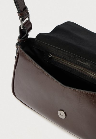 Sac en cuir marron à texture lisse, doté d'un intérieur en tissu noir et d'un compartiment zippé, fermé par un bouton-pression argenté.