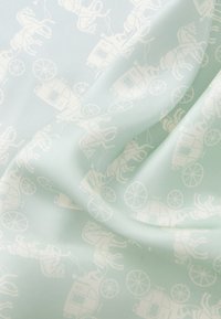 Mint green fabric featuring a repeating white pattern of horses and carriages, showcasing a smooth texture and subtle sheen.