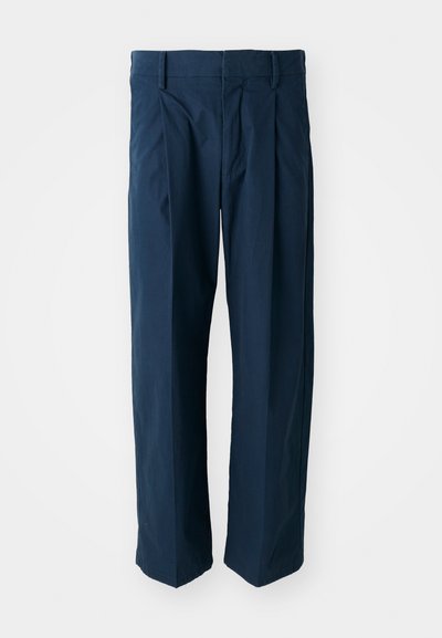 Pantalons bleu marine en coton, présentant une coupe décontractée, des plis plats à l'avant et une taille plate avec passants de ceinture.