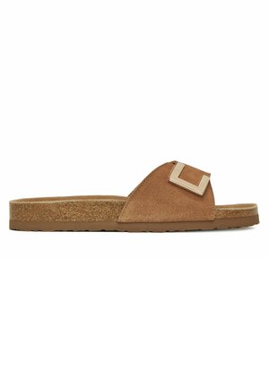 Braune Slipper aus Wildleder mit Korksohle und breitem Riemen, der eine große quadratische Metallschnalle zeigt, Seitenansicht.