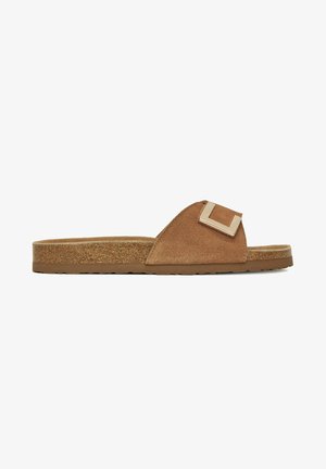 Braune Slipper aus Wildleder mit Korksohle und breitem Riemen, der eine große quadratische Metallschnalle zeigt, Seitenansicht.