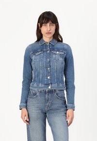 Giubbotto in denim con colletto classico, chiusura con bottoni e due tasche sul petto. Colore azzurro chiaro con texture invecchiata e vestibilità corta.
