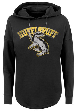 Must musta, millel on graafika puuhapuudist koosneva haljatuigeusega, mille kohal on kollane tekst "HUFFLEPUFF". Kujundatud lõdva istuvuse ja pikkade varrukatega.