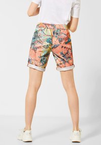 Barevné šortky se vzorem, které mají elastický pas, ohrnuté manžety a tropický design v odstínech oranžové, zelené a modré.