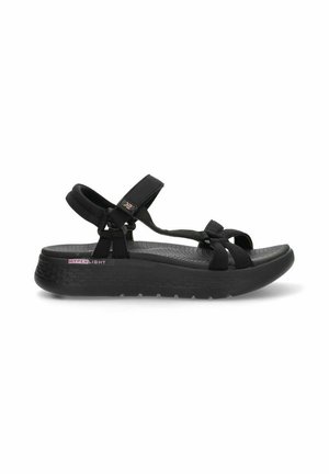 Sandalias negras con correas ajustables, una plantilla texturizada y una suela acolchada con la marca "HYPERLIGHT" en el lateral.