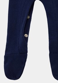 Pyjama à pieds bleu marine en tissu doux. Comprend des boutons-pression sur le côté pour un habillage facile. Design de pied rond avec une texture lisse.