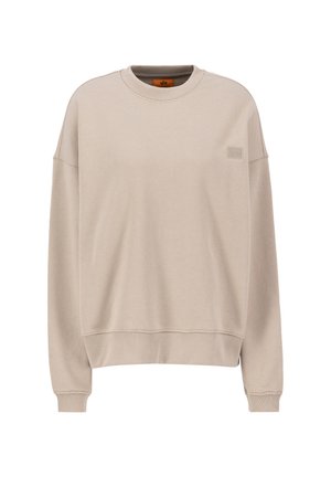 Felpa beige realizzata in morbido tessuto, con scollo rotondo, spalle cadute e una discreta toppa con il logo sul petto.