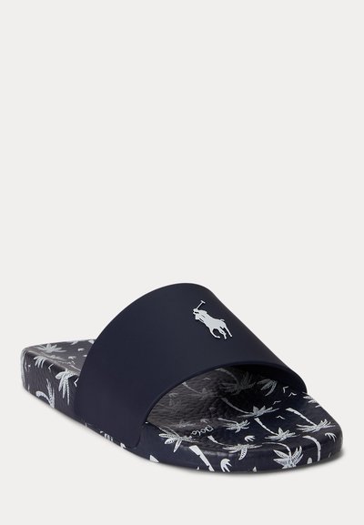 Granatowy klapek na płaskiej podeszwie z białym wzorem palmy na wkładce i podeszwie, z wypukłym logo gracza polo na pasku.