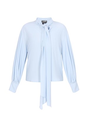 Lyseblå bluse med lange ærmer, med rynkede manchetter og et bundet halstørklæde, der hænger ned foran.