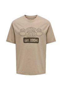 Camiseta de algodón beige de manga corta con un diseño del logo de Central Perk y "EST. 1994" en impresión gráfica marrón en el frente.