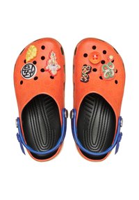 Oranje rubberen klompen met meerdere decoratieve charms en gaten voor ventilatie. Verstelbare blauwe banden en getextureerde zwarte voetbedden.