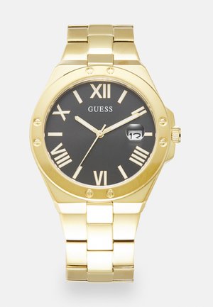 Montre dorée avec un cadran noir. Présente des chiffres romains, une fenêtre de date et un bracelet à maillons. Remarquable par son design de boîtier octogonal élégant.