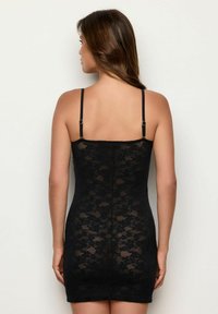 Rochie din dantelă neagră cu o formă ajustată, bretele subțiri reglabile, model floral și o suprafață texturată, concepută pentru a se așeza strâns pe corp.