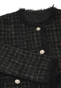 Jachetă din lână texturată neagră, cu un model delicat de carouri argintii, margini franjurate și butoane decorative din perle cu garnituri aurii.