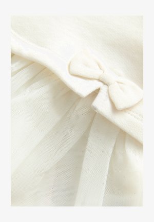 Indumento bianco con una morbida parte superiore in tessuto con un fiocco decorativo e una gonna in tulle a strati che mostra una delicata texture trasparente.