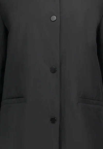 Giacca esterna nera con chiusura a bottoni, due tasche laterali, texture liscia, e un design snello senza motivi visibili.