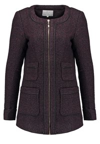 Bunda z vlněné směsi v hluboké švestkové barvě s přiléhavým střihem, předním zipem, kulatým výstřihem a čtyřmi klopovými kapsami zdobenými černým lemováním.