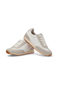 Zapatillas en beige y blanco con una textura suave, que presentan un diseño retro, punta redonda y suela de goma con un patrón en zigzag.