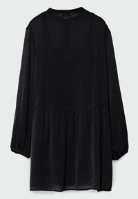 Robe noire à manches longues avec un motif subtil en points texturés, taille froncée et poignets élastiques, vue de dos.