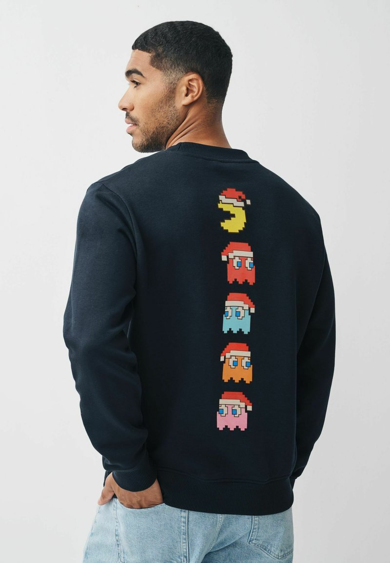 Felpa navy in cotone, con personaggi in pixel art dai colori rosso, blu, rosa e giallo sul retro. Collo a giro e polsini a coste.