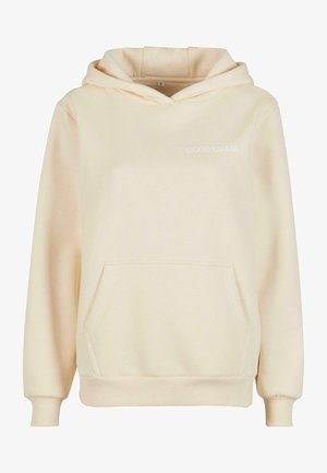 Kreemjas kapuutsiga särk, mis on valmistatud pehmest kangast, millel on taskud ja mansetid. Ees on valget värvi trükk "GOODKARMA".