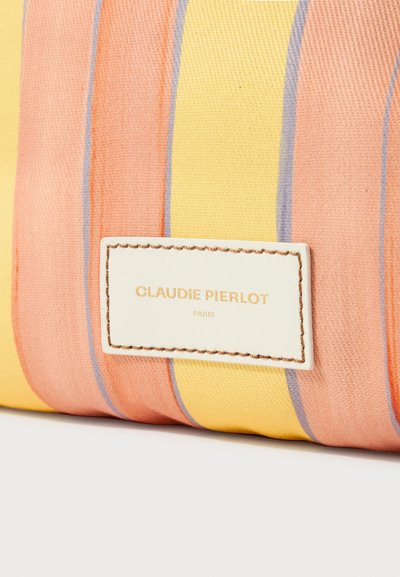 Sac à main en tissu rayé aux tons jaunes, roses et violets, avec une surface texturée et une étiquette blanche embossée avec "CLAUDIE PIERLOT PARIS."