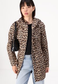 Leopard-print coat with a hood, made of smooth fabric. Long sleeves, front zipper, worn over a black top and light blue jeans. Black bag.