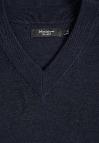 Tamsiai mėlynas merino vilnos megztinis su V formos iškirpte. Savybės: suplotos iškirptės ir lygi tekstūra. Etiketėje užrašyta "Martinique 100% Merino, L".