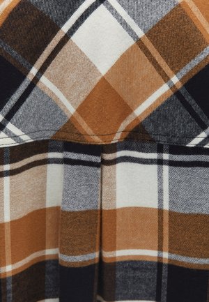 Plaid fabric in orange, brown, navy, and white. Features a grid pattern and soft texture, with horizontal and vertical lines forming squares.